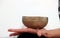 Musical instrument - singing Himalayan bowl. The singing bell holds the girl in his hand. The practice of healing vibrations,