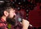 Musician with beard and mustache singing song in karaoke. Punk rock concept. Man with tense face holds microphone