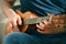 A musician in blue clothes plays a cheerful tune on an ukulele