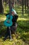 A musician with blue hair and a blue guitar resting in the park