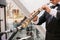 A musician at the event in a frock coat and bow tie plays the saxophone. Ð¡lose-up of hands and tools.