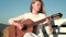 Musician girl playing guitar. Women relaxing with music.