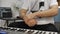 Musician having wrist pain while playing midi keyboard in home music studio.