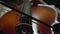 Musician leads bow along strings of cello playing classical music, closeup, front view. Musician performs playing