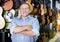 Musician male is standing near rows of acoustic guitars