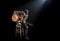 Musician playing acoustic guitar, sitting on high chair, black background with beautiful soft light