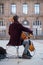 Musician playing with cello on a cobbles place in front of the cathedral