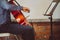 Musician playing cello with musical notes on the book notation stand in front of him