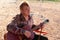 Musician playing a guitar sitting outdoors