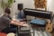 Musician playing midi keyboard in home music studio