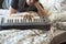 Musician playing synthesizer on unmade bed