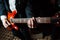 The musician plays the electric guitar on stage. Guitar neck close-up on a concert of rock music in the hands of a musician.