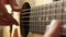 The musician plays a melody on a yellow acoustic guitar, close-up