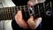 A musician plays solo on a white electric guitar on a black background, close-up. The man is playing rock.