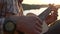 A musician plays on the ukulele close-up of his hands and the fretboard of a guitar.