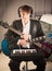 Musician portrait in studio with two guitars and keyboard