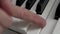 The musician's finger presses on all the piano keys