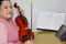 Musician teacher teaches violin at home online using laptop