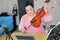 Musician teacher teaches violin at home online using laptop