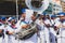 Musicians in a band are playing brass instruments during the pre-carnival Fuzue parade