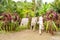 Musicians playing handmade pan flute and drumming handmade drums, Solomon Islands. Musicians between tropical vegetation