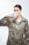 Musing female soldier drinking coffee