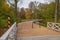 Muskau Park and wooden bridge over Neisse river at autumn morning. German-Polish border