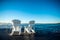 Muskoka Chairs on a dock with sun rising and mist