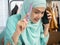 Muslim Asian woman working on designer studio workspace with smartphone