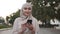 Muslim beautiful woman in pastel hijab with makeup standing on the street holding smartphone while have a walk in the