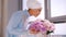 Muslim bride in blue wedding dress for nikah, smelling flowers