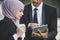 Muslim Businessman and businesswoman partner discussing using tablet for work. Outdoor Setting