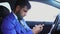 Muslim businessman sitting in the car and typing on the smartphone