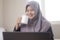 Muslim Businesswoman Taking Coffee Break While Working in Home