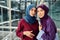 Muslim caucasian girlfriends with hijabs pose in modern business centre