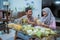 muslim couple asian making ketupat rice cake at home using palm leaf