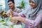 muslim couple making ketupat for idul fitri traditional delicacy