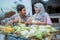 muslim couple making ketupat for idul fitri traditional delicacy