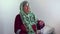 Muslim elderly woman praying on her bed in her room