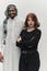 Muslim entrepreneur and a contemporary red-haired girl strike a pose together against a clean white background