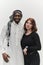 Muslim entrepreneur and a contemporary red-haired girl strike a pose together against a clean white background