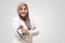 Muslim female doctor wearing hijab and suit, standing with crossed arm and holding stethoscope, succesful confident person