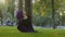 Muslim girl in hijab Islamic woman female yogi sportswoman practicing yoga workout in park on green lawn sits in twine