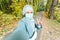 Muslim girl in a medical mask makes a selfie. Portrait of islamic arabian woman in park during a pandemic.