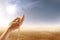 Muslim hands praying with prayer beads on desert