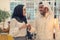 Muslim hijab woman share bitcoin with arabian businessman.