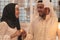 Muslim hijab woman share bitcoin with arabian businessman.