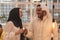 Muslim hijab woman share bitcoin with arabian businessman.