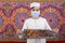 Muslim kid presenting a tray of Arabian dates in Ramadan