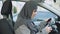 Muslim lady sitting in car starting engine and looking in mirror driving license